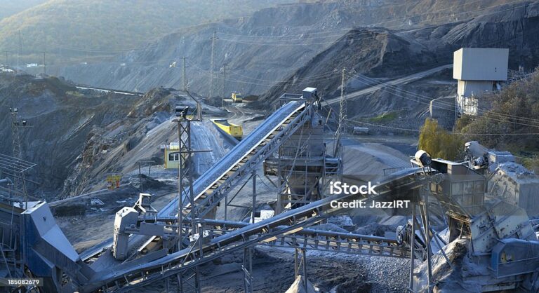 "Stone quarry with silos, conveyor belts, and piles of stones"