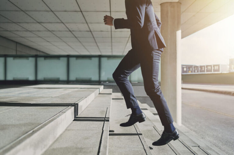 Man wearing suit runs up the stairs